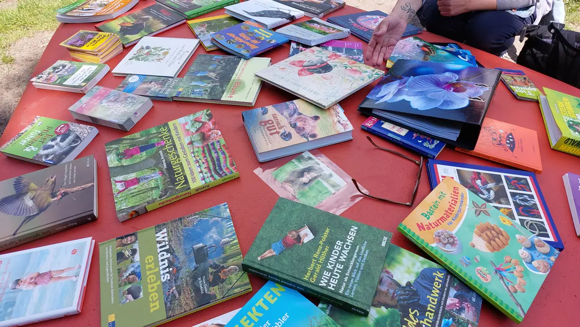 Natur- und Wildnispädagogik-Bücher und Materialien auf einem Tisch.